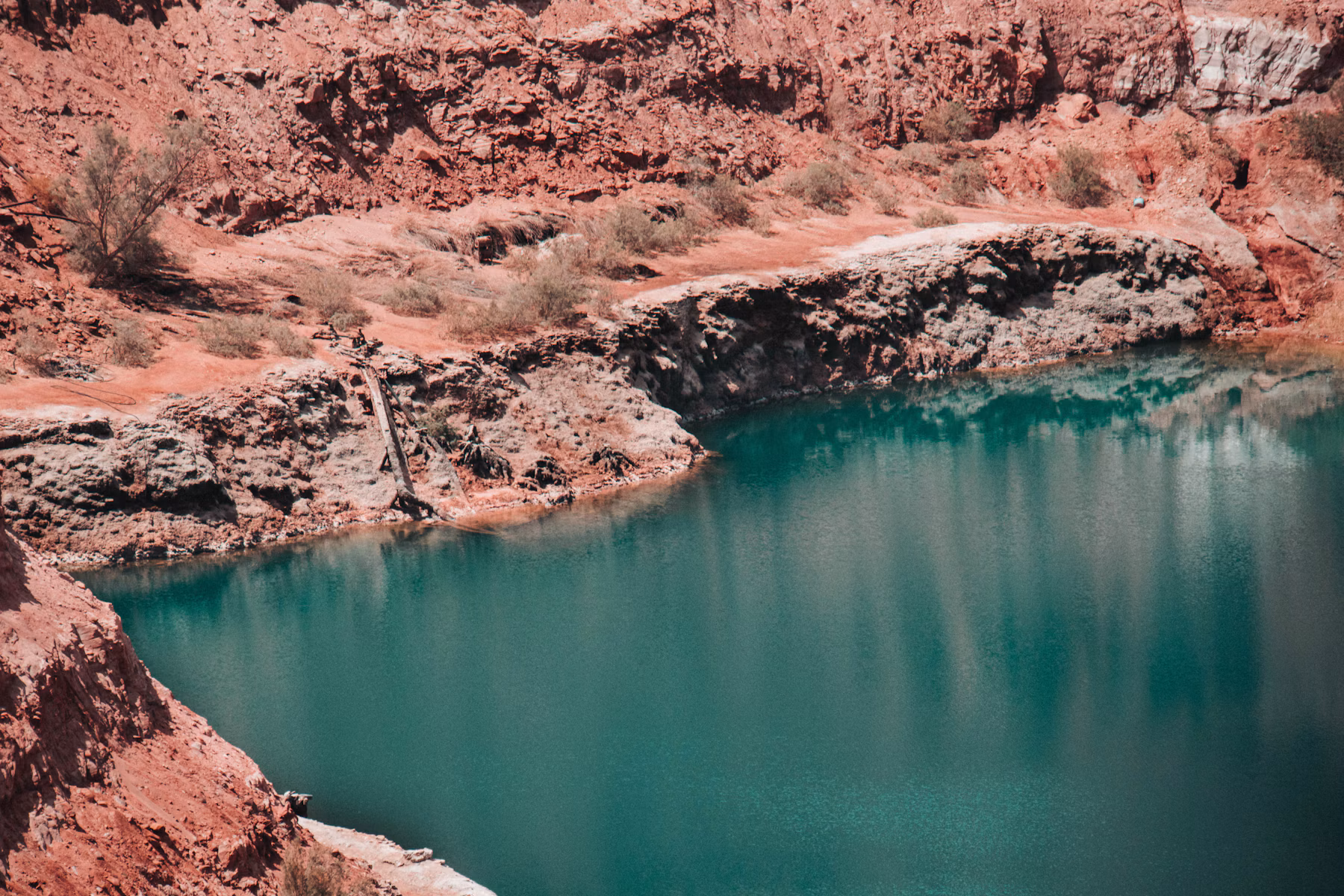 Blue desert reservoir surrounded by red rock